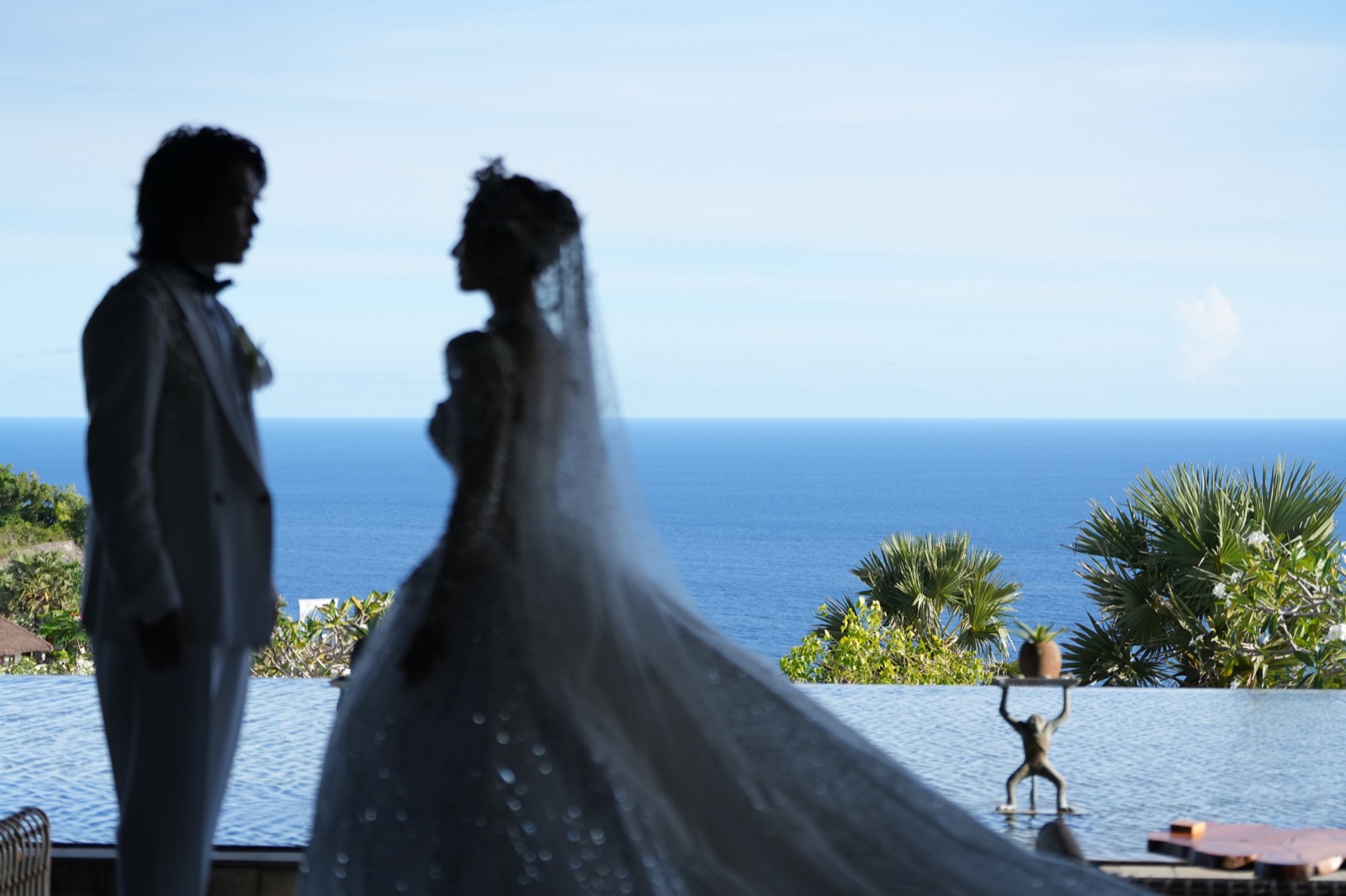 Two silhouettes at an infinity pool above the sea, Uluwatu